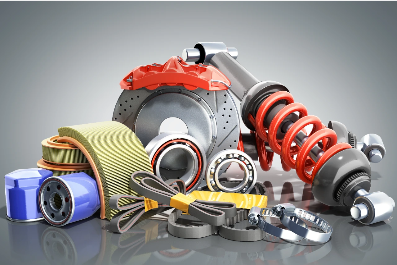 القلاف_للدراجات_النارية_ أجزاء سيارة متنوعة تشمل قرص مكابح وممتص صدمات وفلتر زيت وفلتر هواء ومحامل وأحزمة وتروس مرتبة على سطح عاكس. _دراجة_نارية